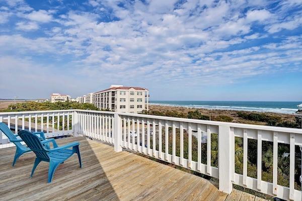 Deck with blue chairs and ocean views at The North Seas vacation rental in North Carolina.